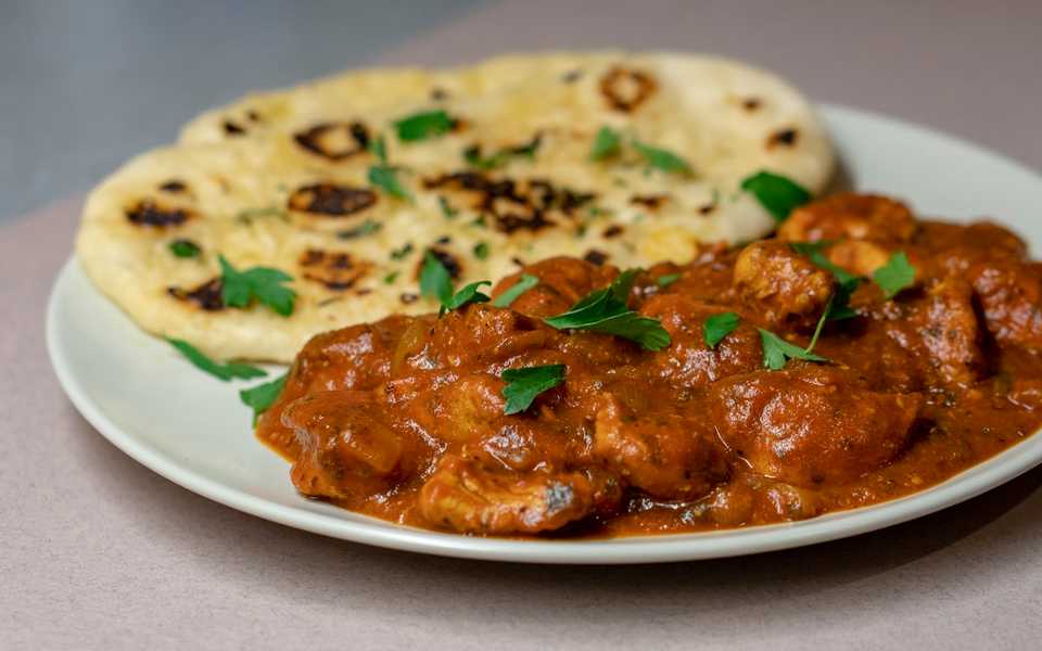 Chicken biryani with rice, herbs, and lemon.