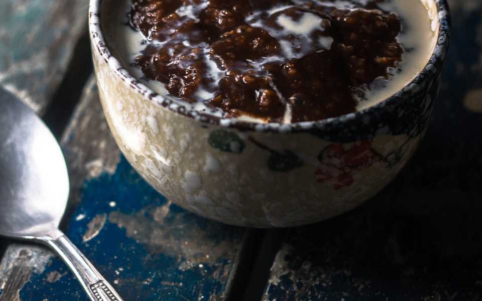 Creamy rice pudding topped with syrup in a bowl.