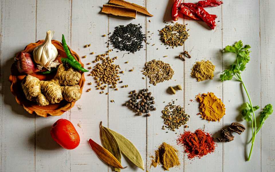 Assorted whole and ground spices in small bowls.