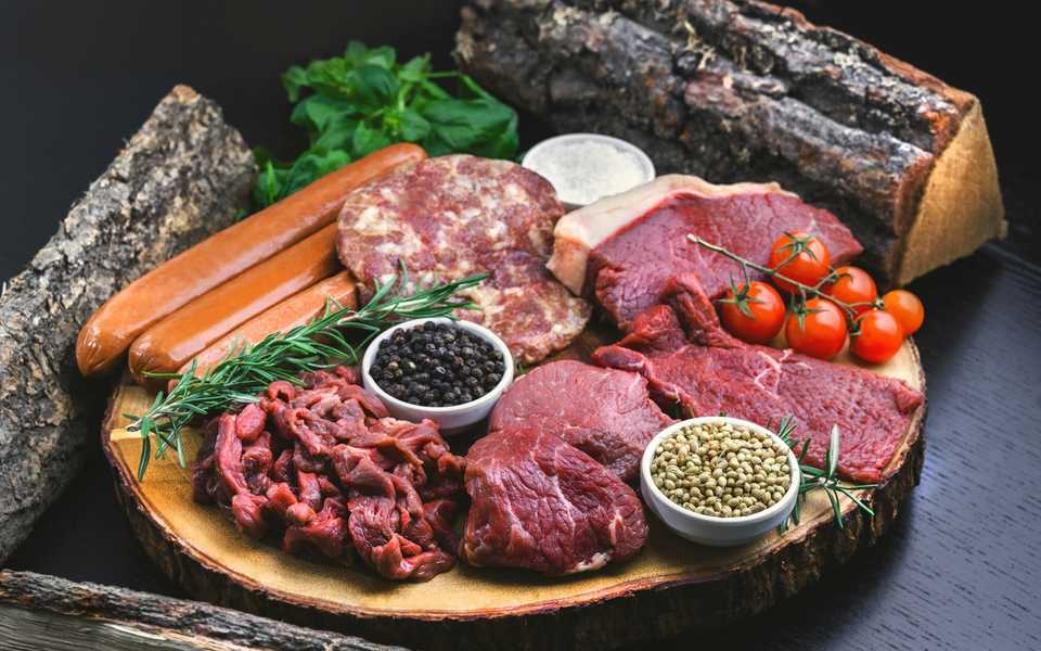 Fresh cuts of meat presented at a butcher counter.